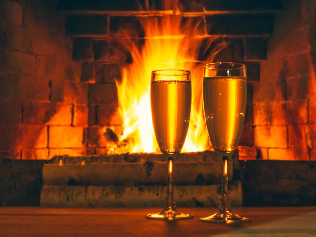 Champagne glasses in from of a fireplace